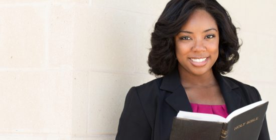 Pastoral Counseling Degrees can lead to a rewarding career path. African American pastoral counseling student happily reading the Bible.
